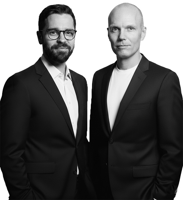 Two men standing wearing suits